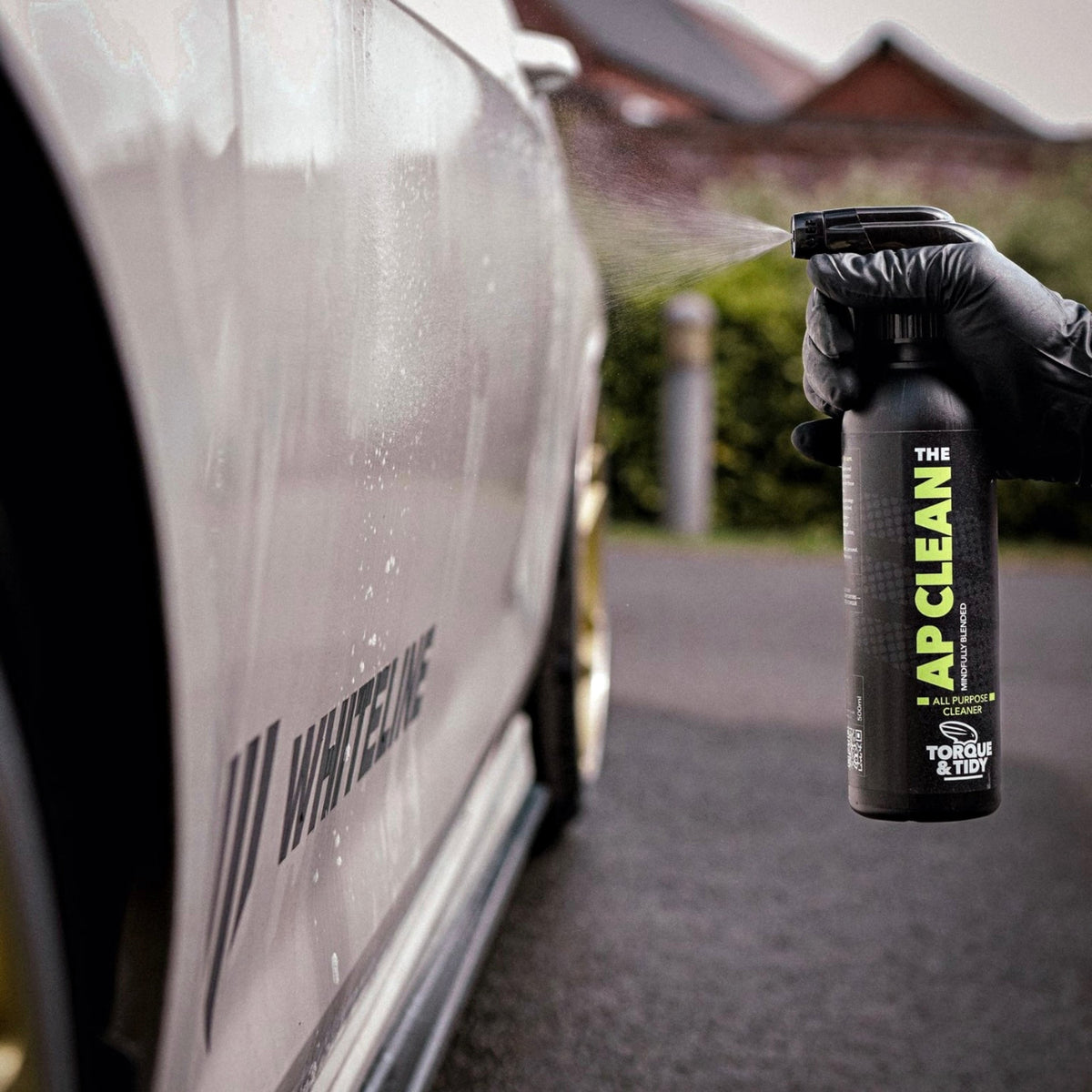 Spraying The AP Clean onto the side of a white car