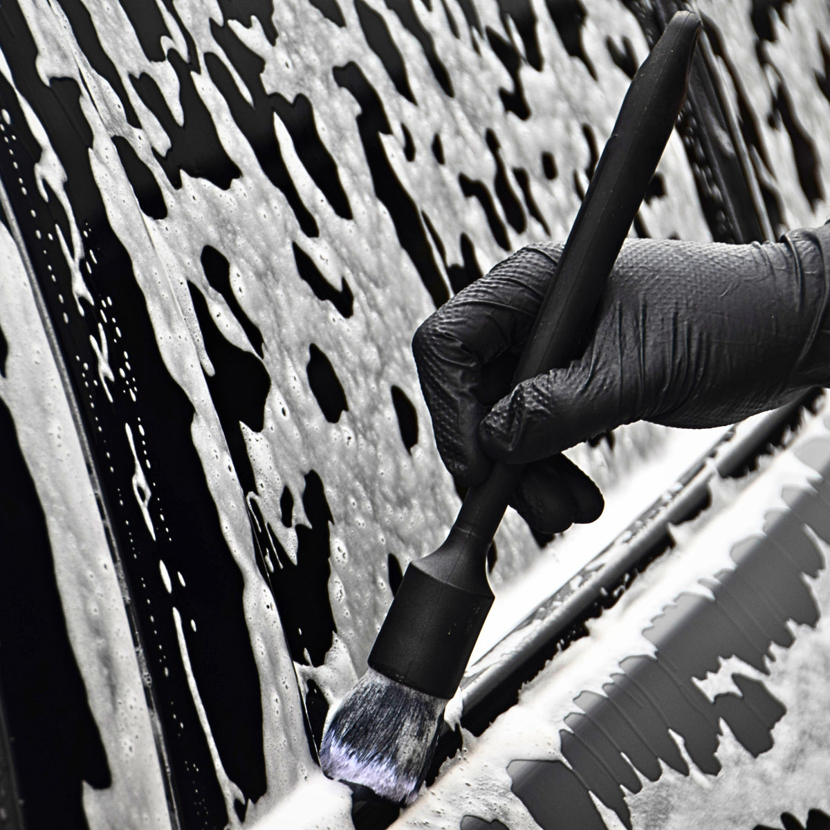 Cleaning a foam-covered badge with a detailing brush