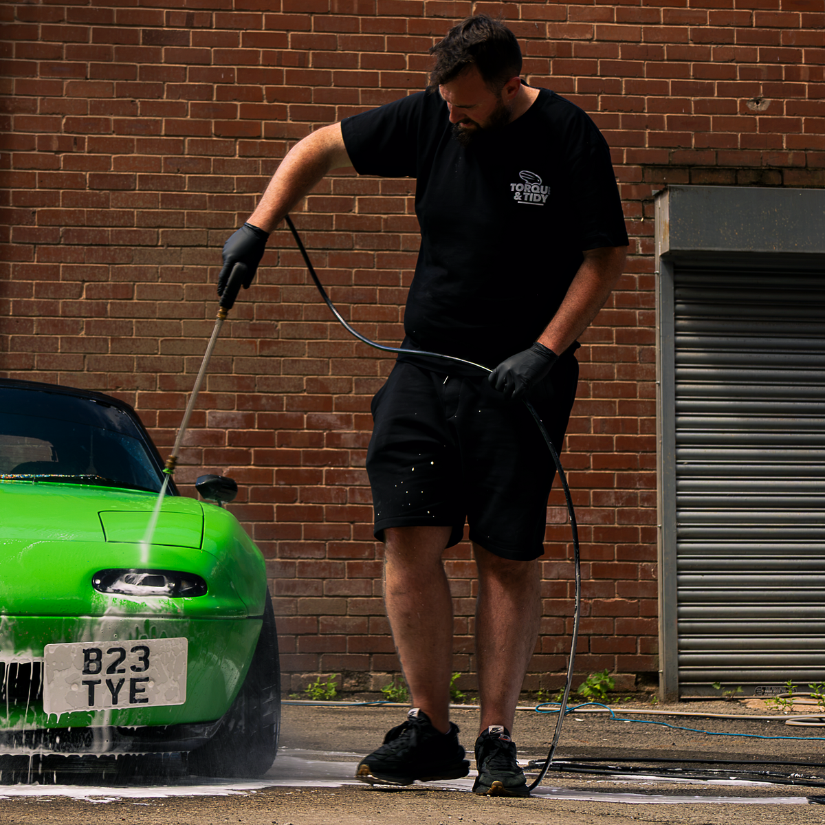 Rinsing a car with a pressure washer