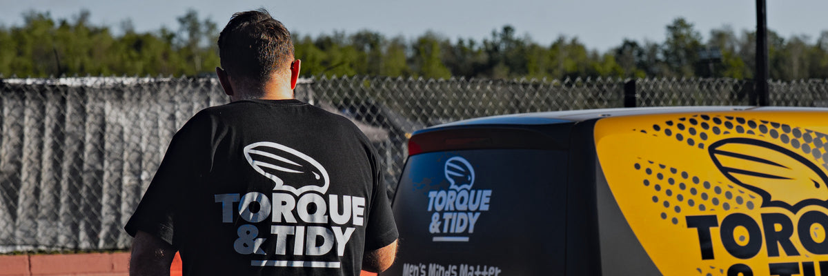 The Torque & Tidy logo tee from the back, beside the T&T van