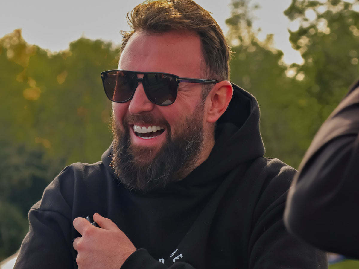 A member of the T&T crew laughing in a T&T hoodie at an event