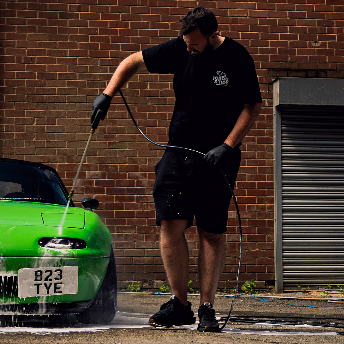 Rinsing a car with a pressure washer