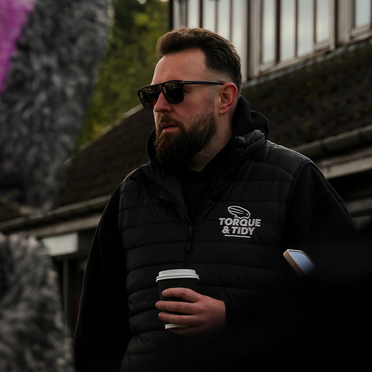 The Gilet in black with Torque & Tidy chest logo, worn
