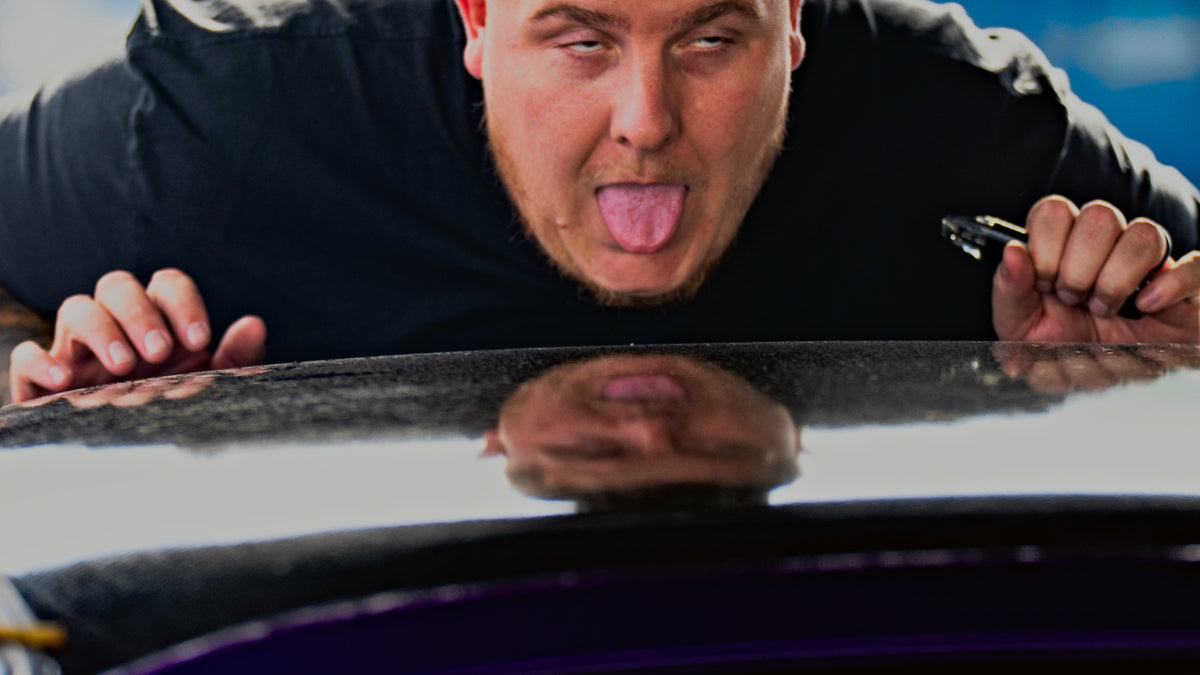 A driver leaning over the roof of his drift car at a Drift League GB event