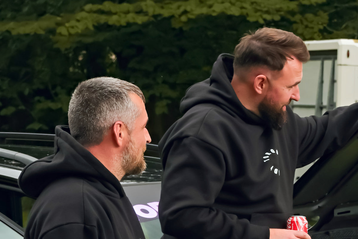 Two of the Torque & Tidy crew in T&T hoodies at a car in the paddock